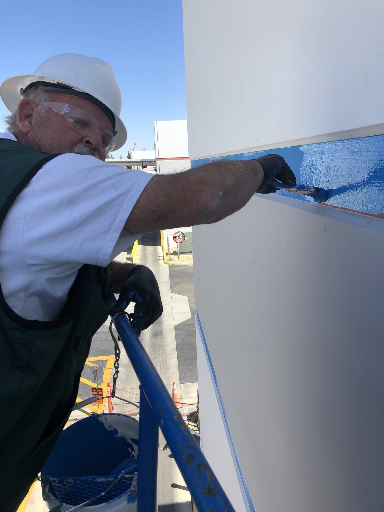 Rusty Crawford painting a commercial building from a boom lift
