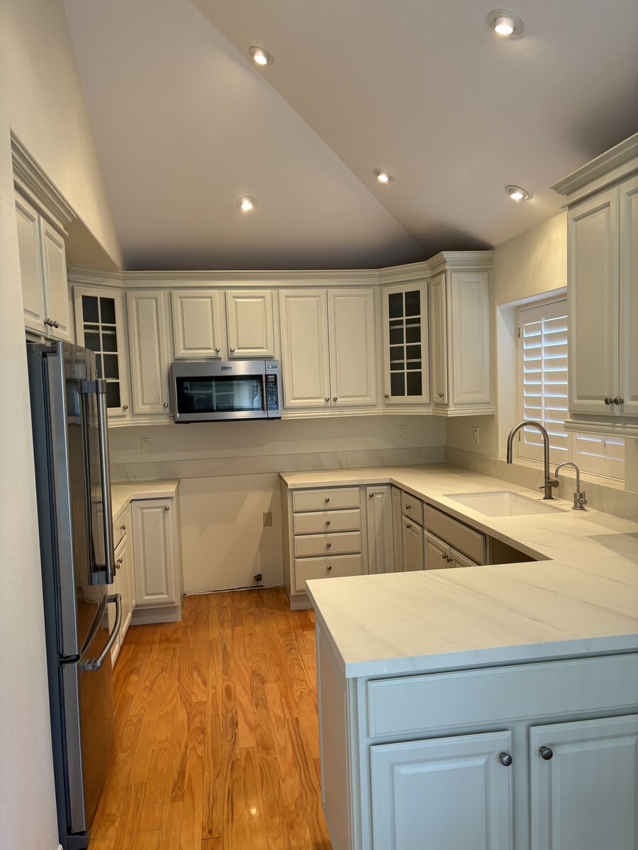 High-end kitchen with professionally painted white cabinets and marble counters